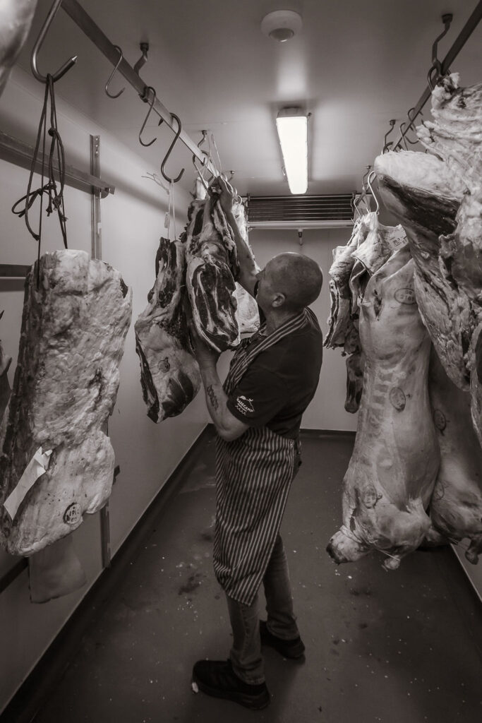 Master butcher preparing whole carcasses in the chiller at Basecamp North Lakes